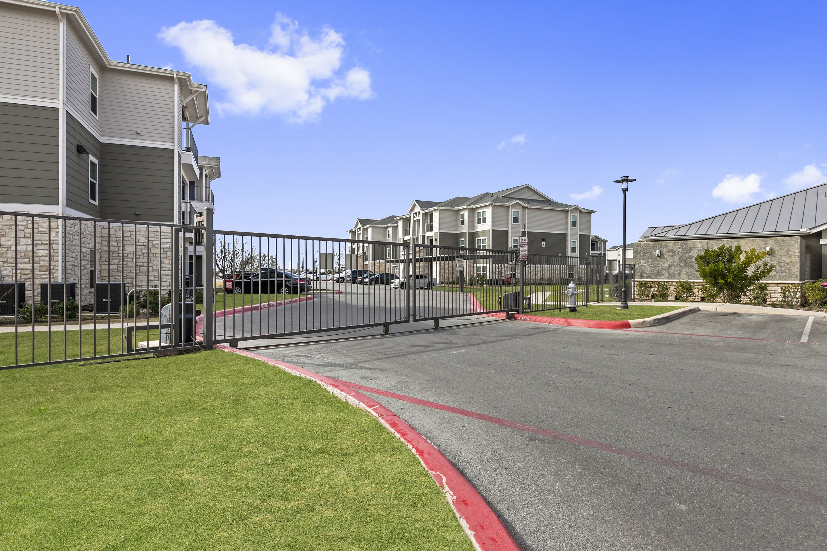 the entrance to a building with a fenced in parking lot