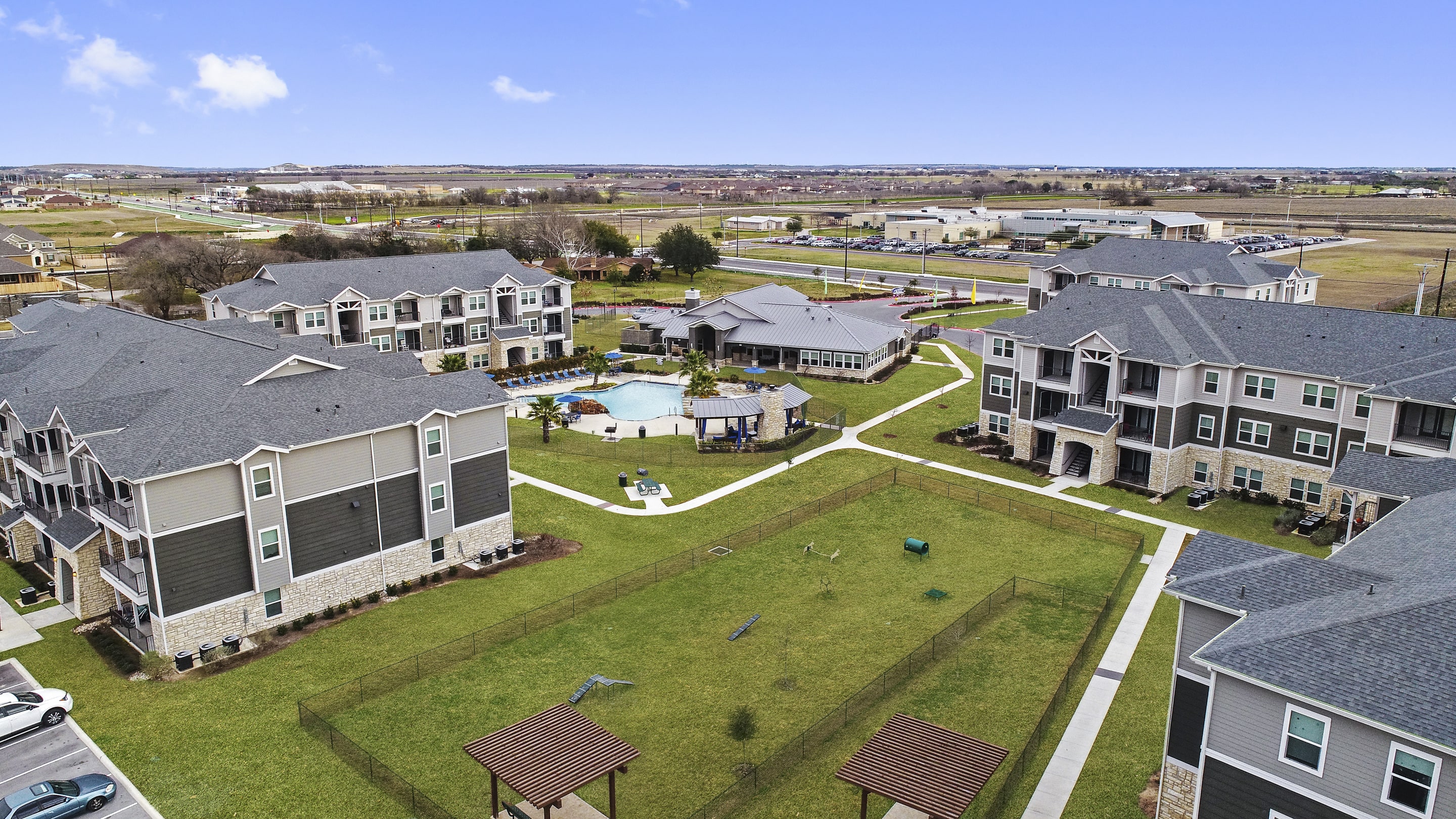 an aerial view of a group of houses and a swimming pool