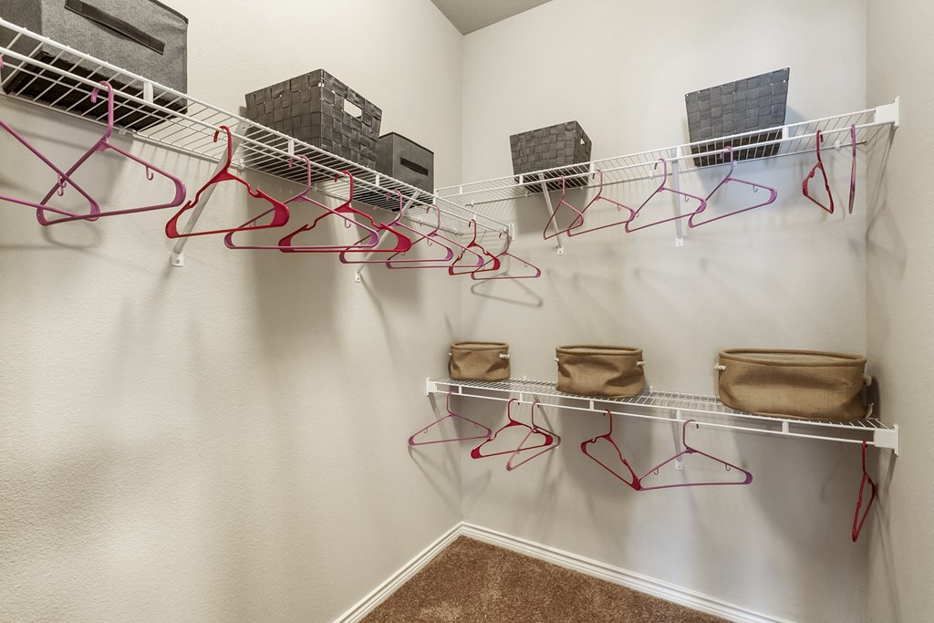 an empty closet with hooks and glasses on the wall