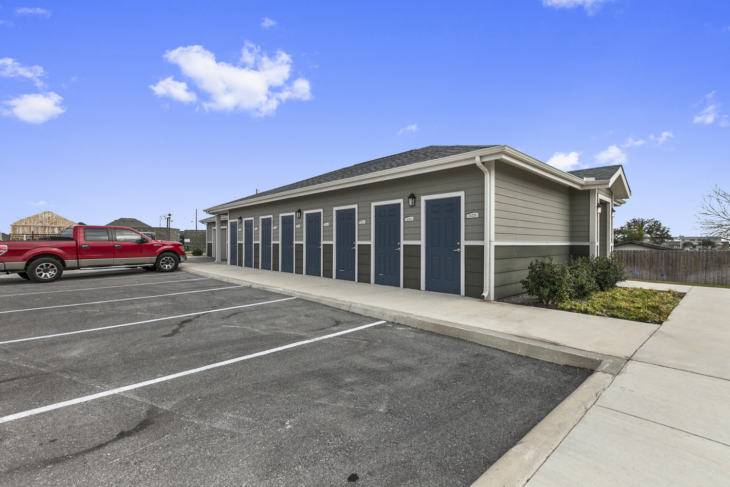 a parking lot with a red truck parked in front of a building