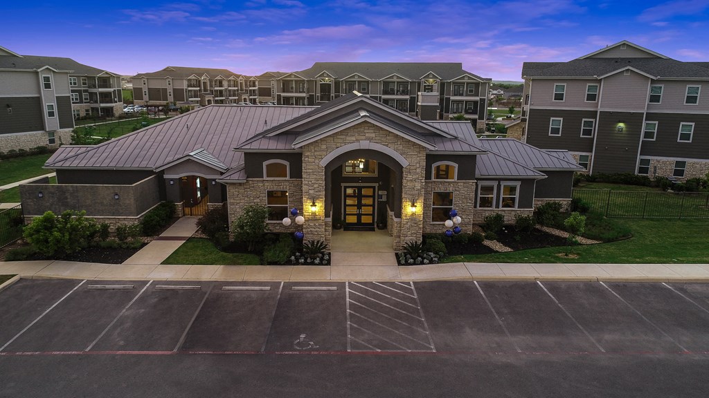 an aerial view of an apartment building with a parking lot