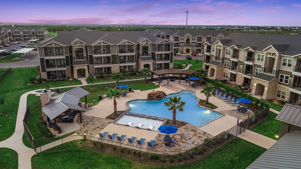 an aerial view of an apartment complex with a large swimming pool