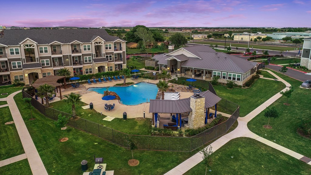 an aerial view of a large swimming pool with apartments in the background