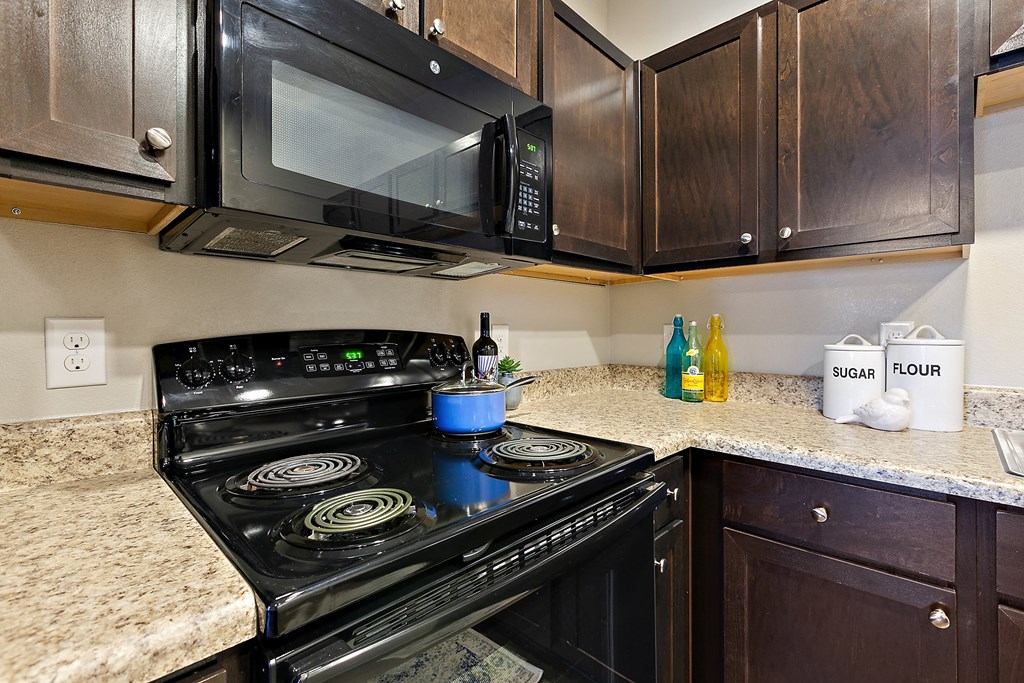 a kitchen with a stove and microwave and a counter top