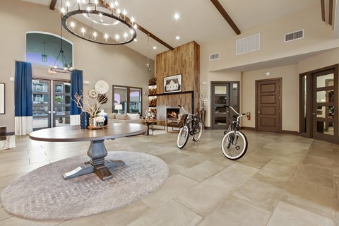 a large living room with a table and two bikes in it