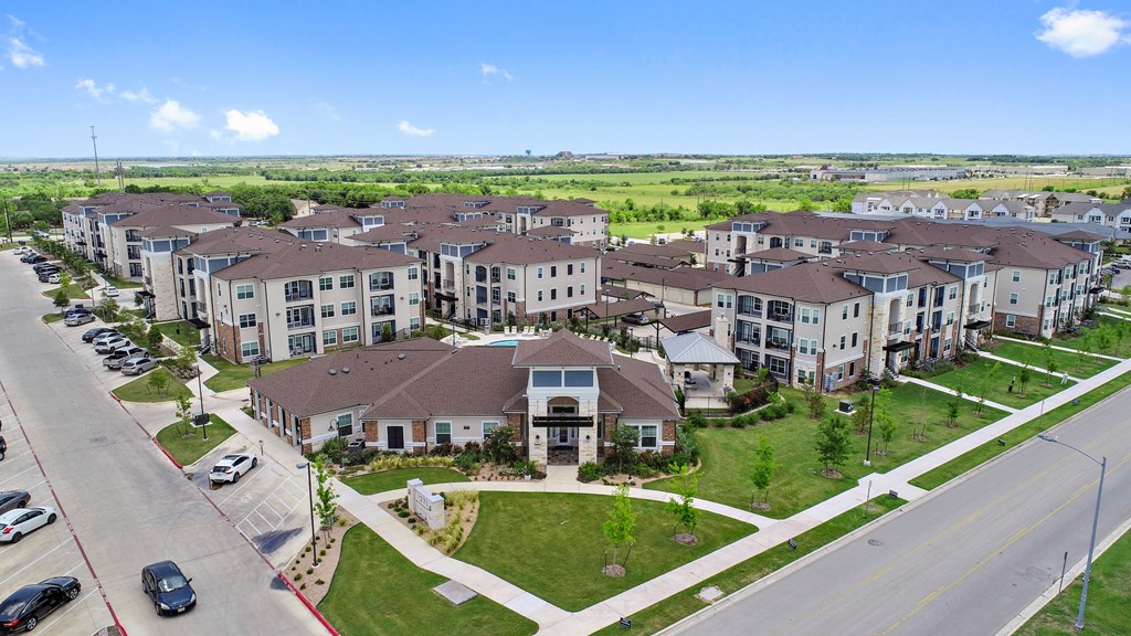 an aerial view of an apartment complex with cars parked in front of it