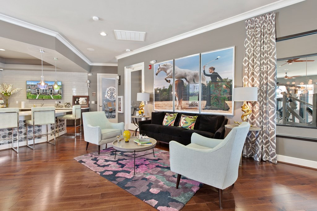 a living room with a black couch and two white chairs