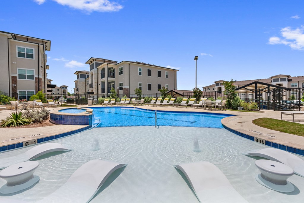a large swimming pool with apartments in the background