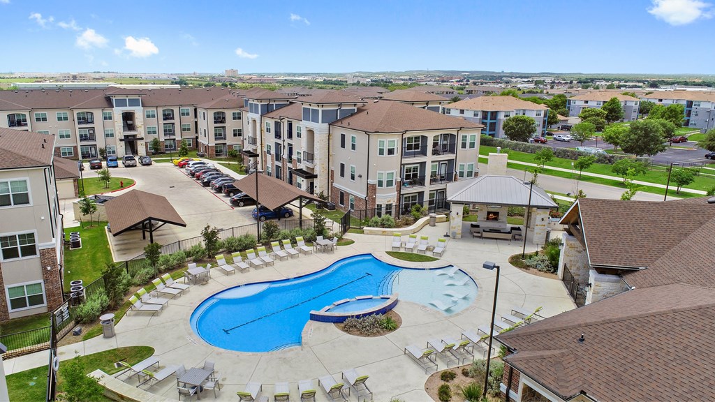 an aerial view of a large swimming pool in front of an apartment building