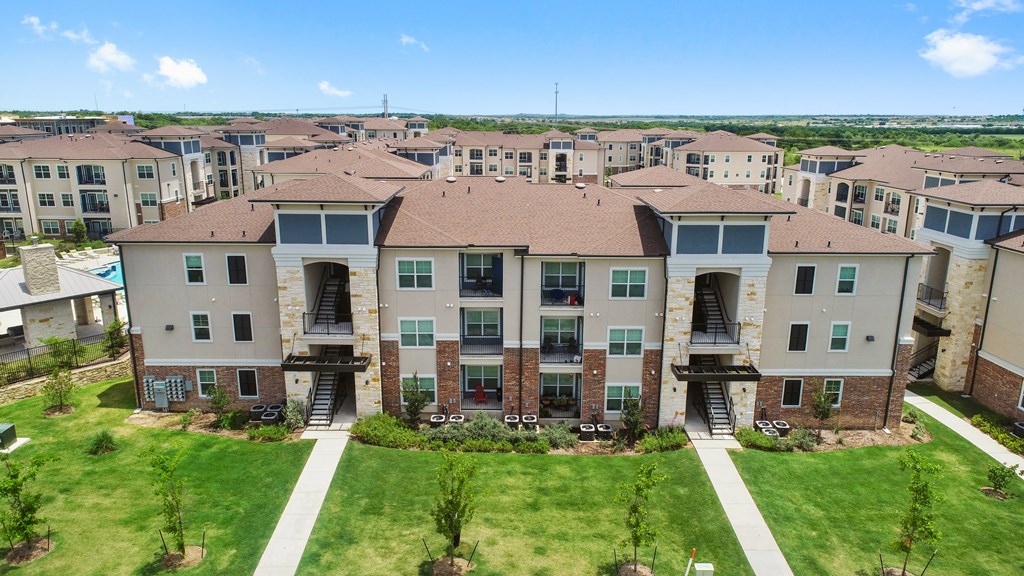 an aerial view of an apartment complex with green grass