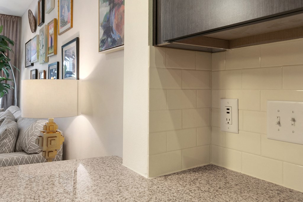 a living room with a couch and a wall with a light switch