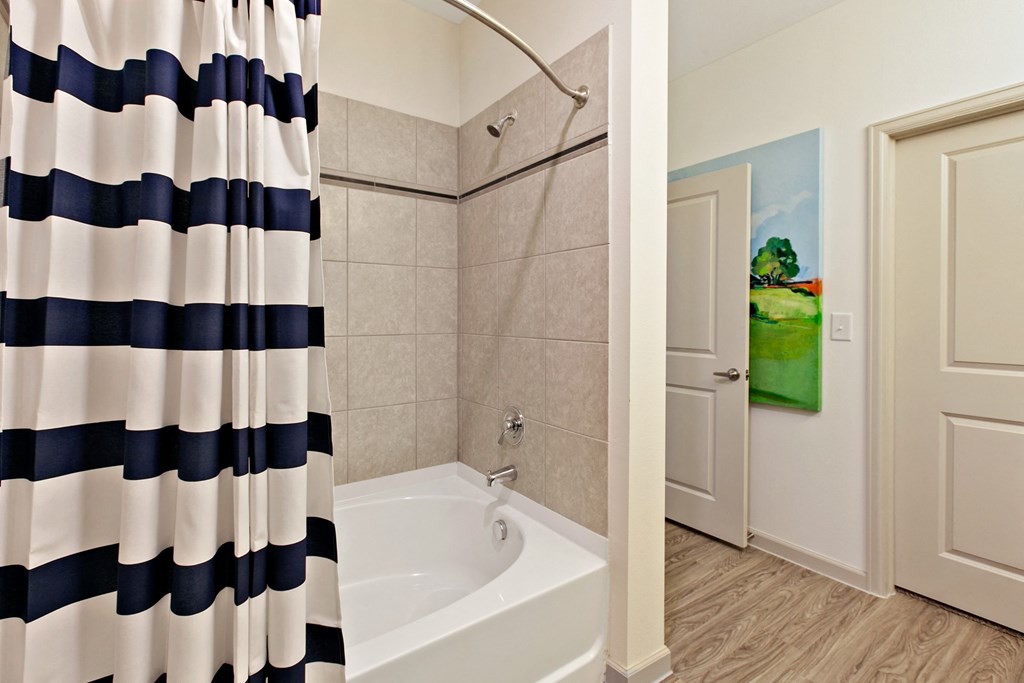 a bathroom with a tub and shower and a shower curtain