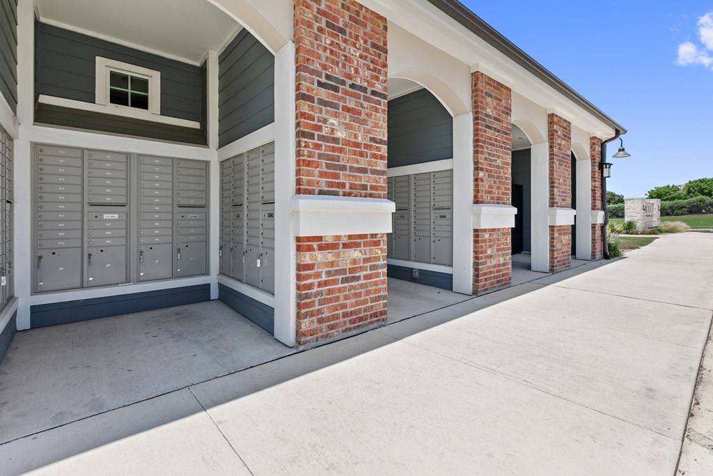 the front of a building with gray doors and a sidewalk