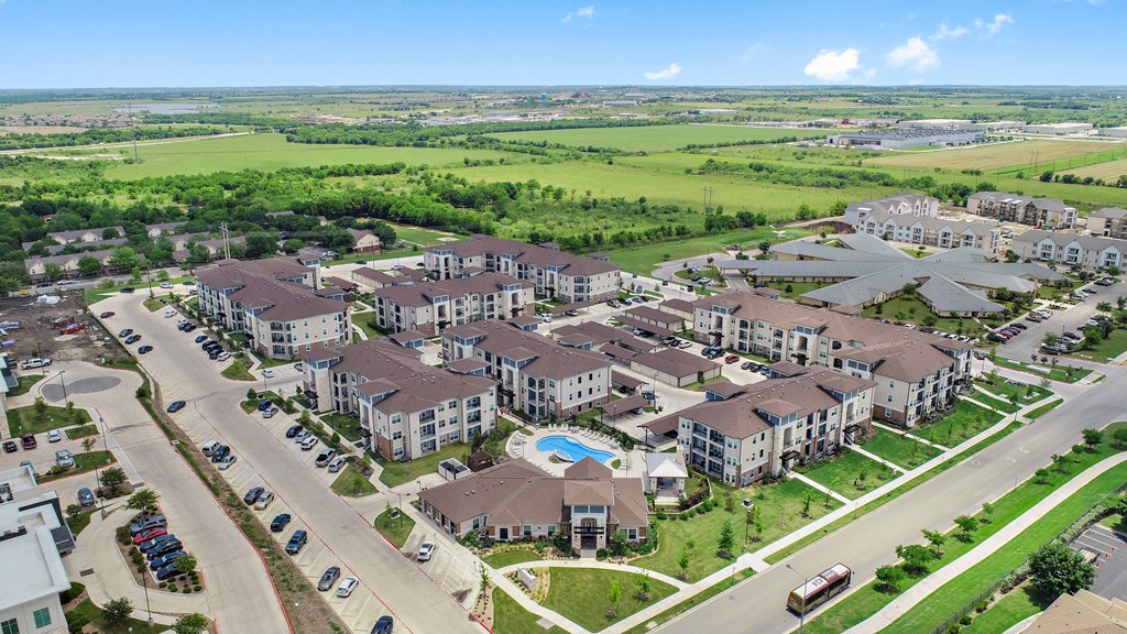 an aerial view of an apartment complex with a swimming pool