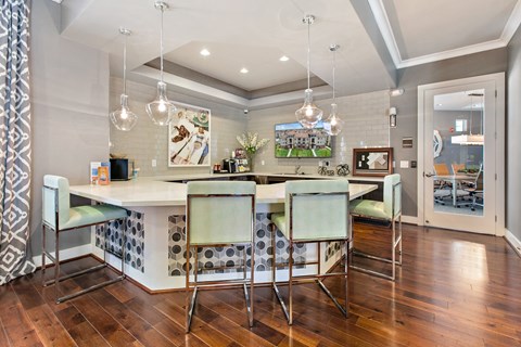 a kitchen with a bar and a dining area with chairs