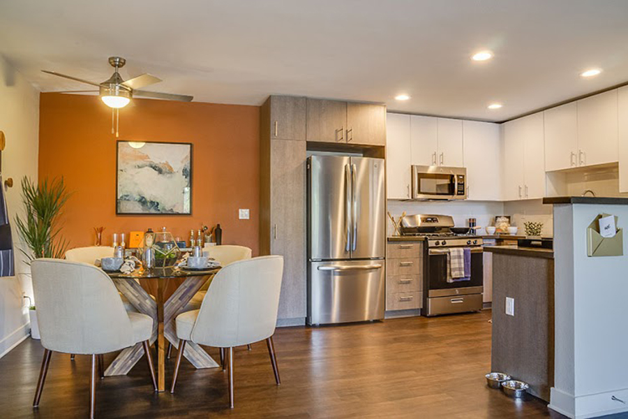 A modern kitchen with a dining table set for two.