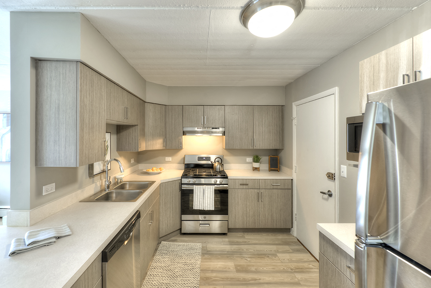 A modern kitchen with a stainless steel refrigerator and wooden cabinets.