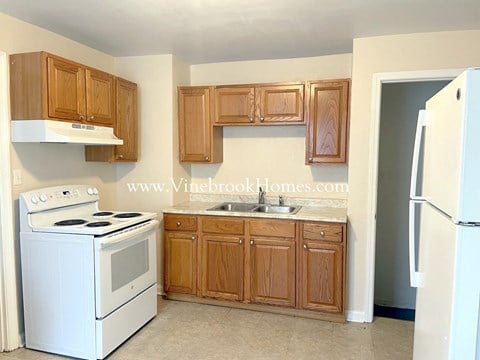 a small kitchen with white appliances and wooden cabinets