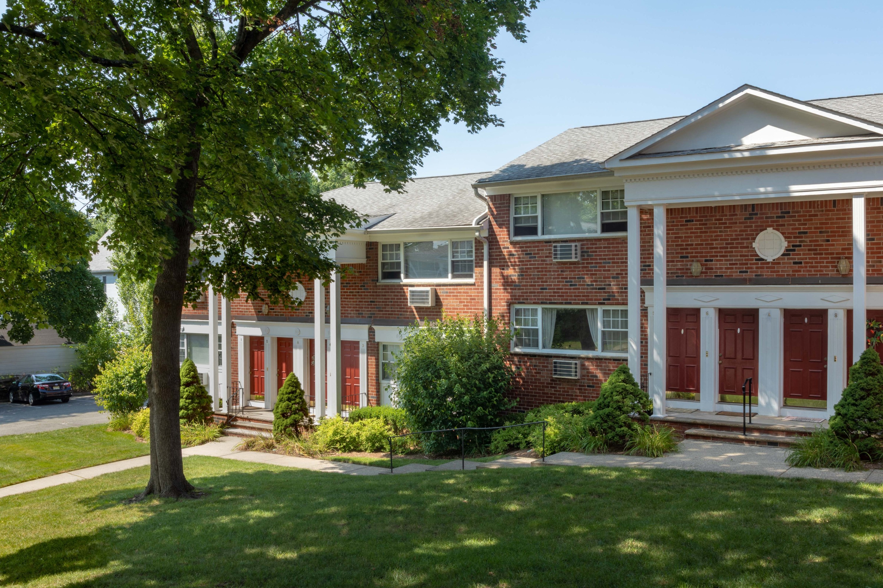 a red brick house with a tree in front of it