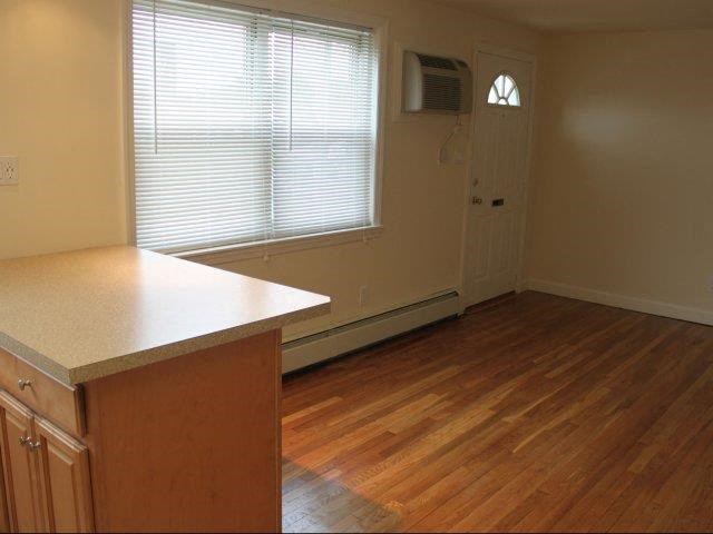 an empty living room with a microwave and a window