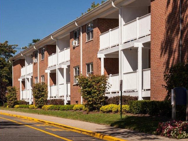 a red brick apartment building with white balconies