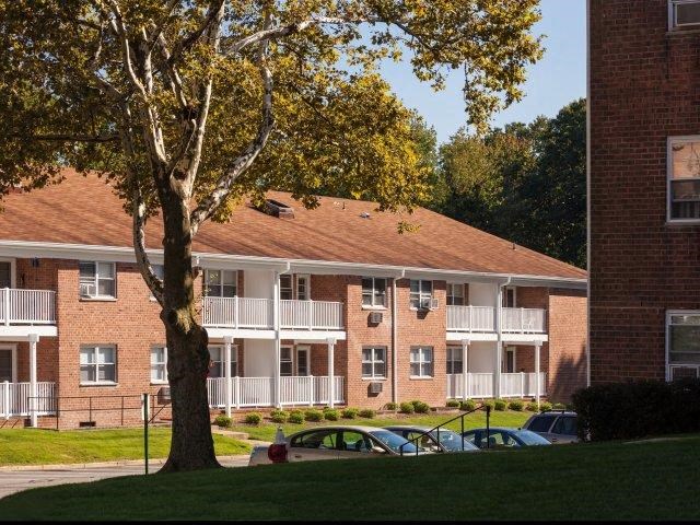 a brick apartment building with cars parked in front of it