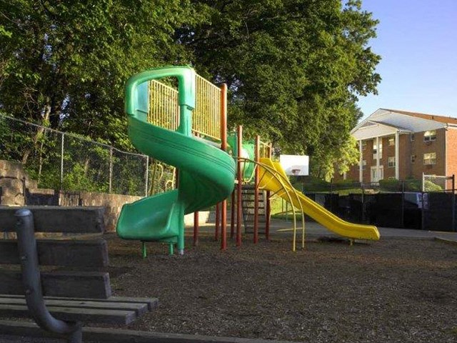 a green and yellow slide in a playground