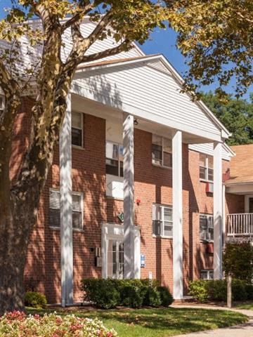 a red brick building with a tree in front of it