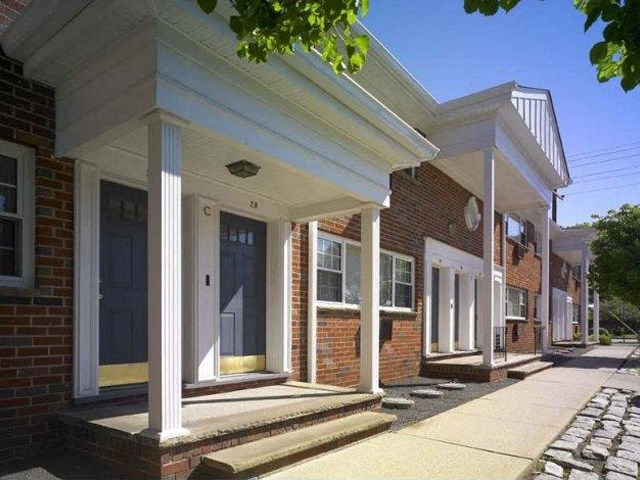 the front porch of a brick building with columns