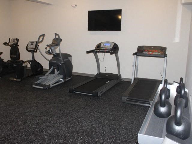 a workout room with exercise equipment and a tv