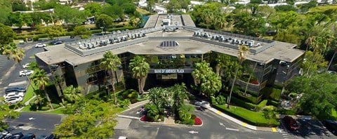 an aerial view of a large building with palm trees
