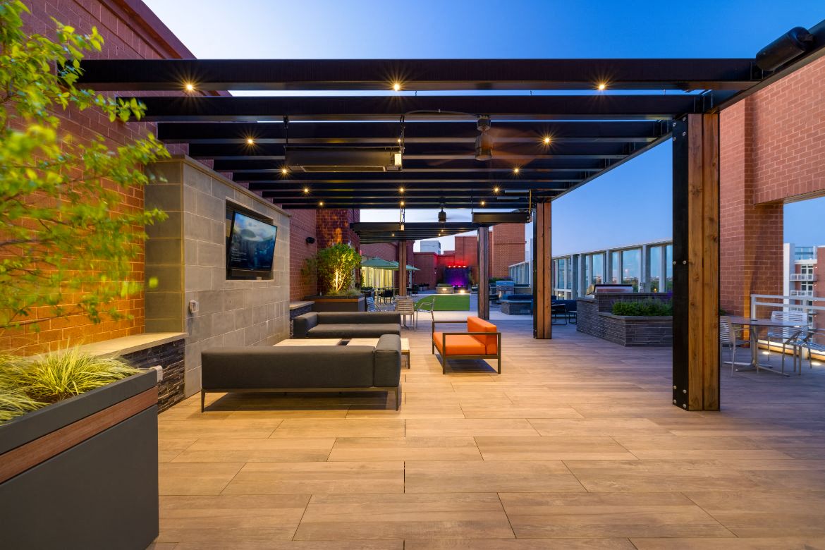a patio with couches and chairs under a roof