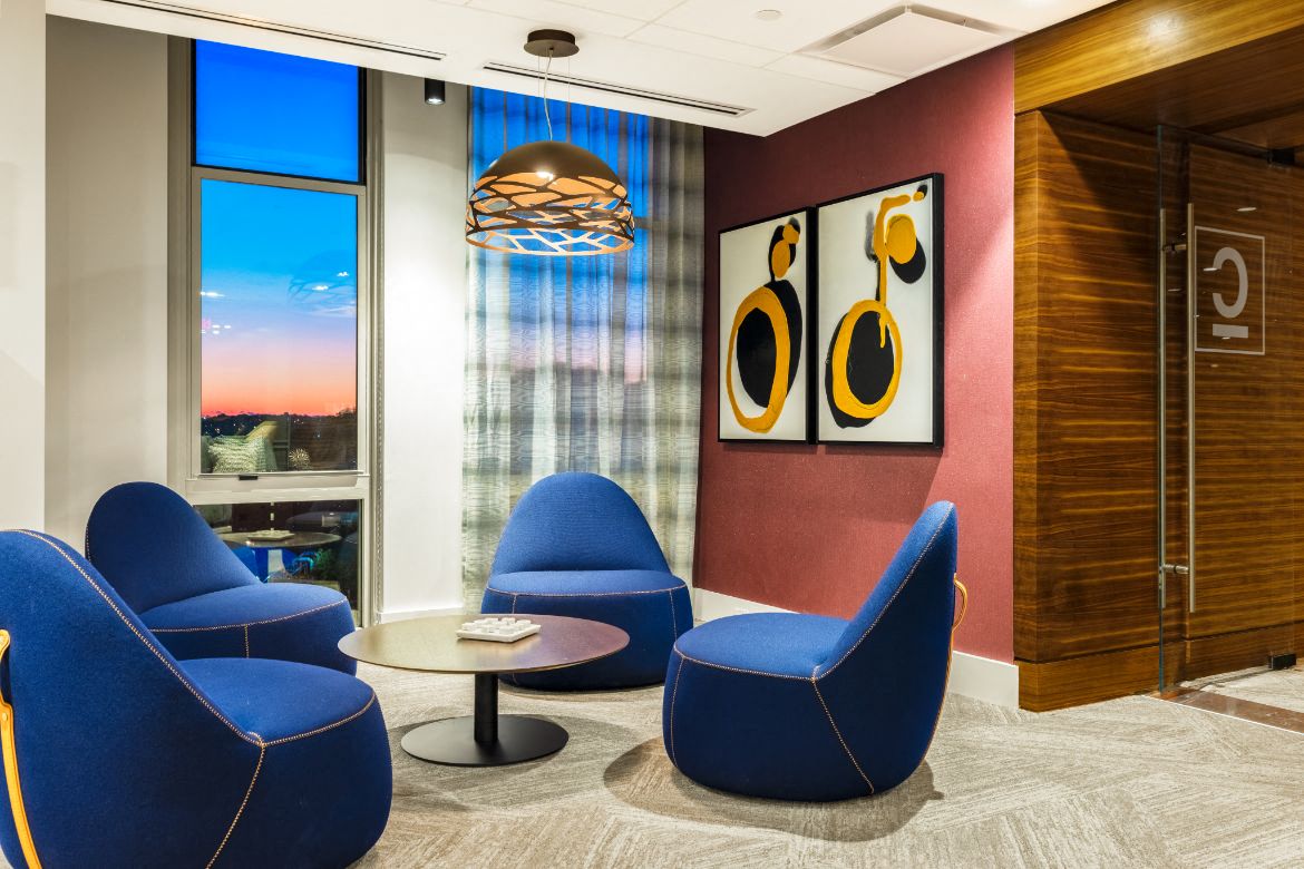 a room with chairs and a table and a painting on the wall