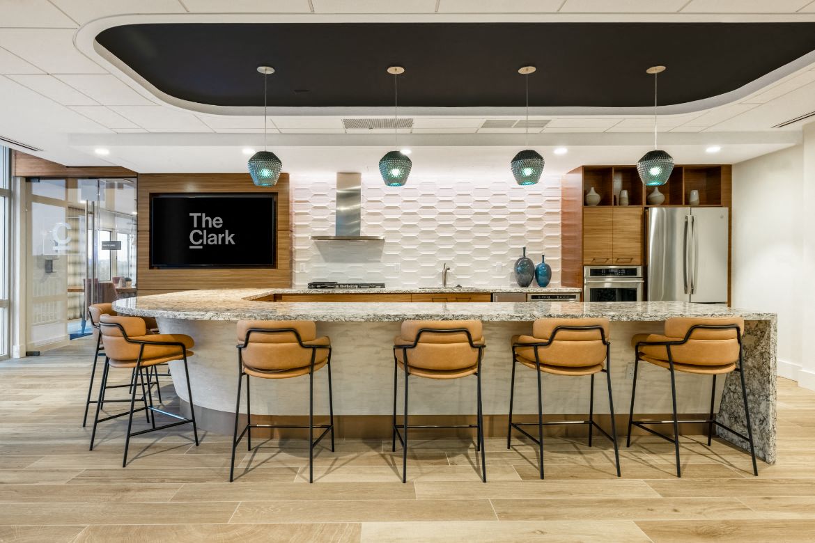 a large kitchen with a counter and chairs