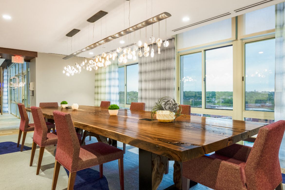 a dining room with a wooden table and chairs and large windows