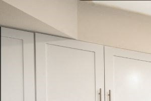 a kitchen with white cabinets and a stainless steel refrigerator