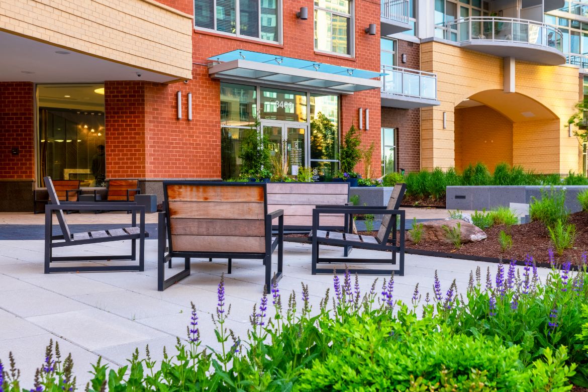 a patio with tables and chairs in front of a building