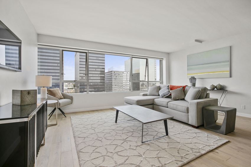 Apartments in Koreatown, CA - The View Apartments Living Room with Hardwood-Style Flooring and Large Windows Providing Skyline Views - Photo Gallery 1