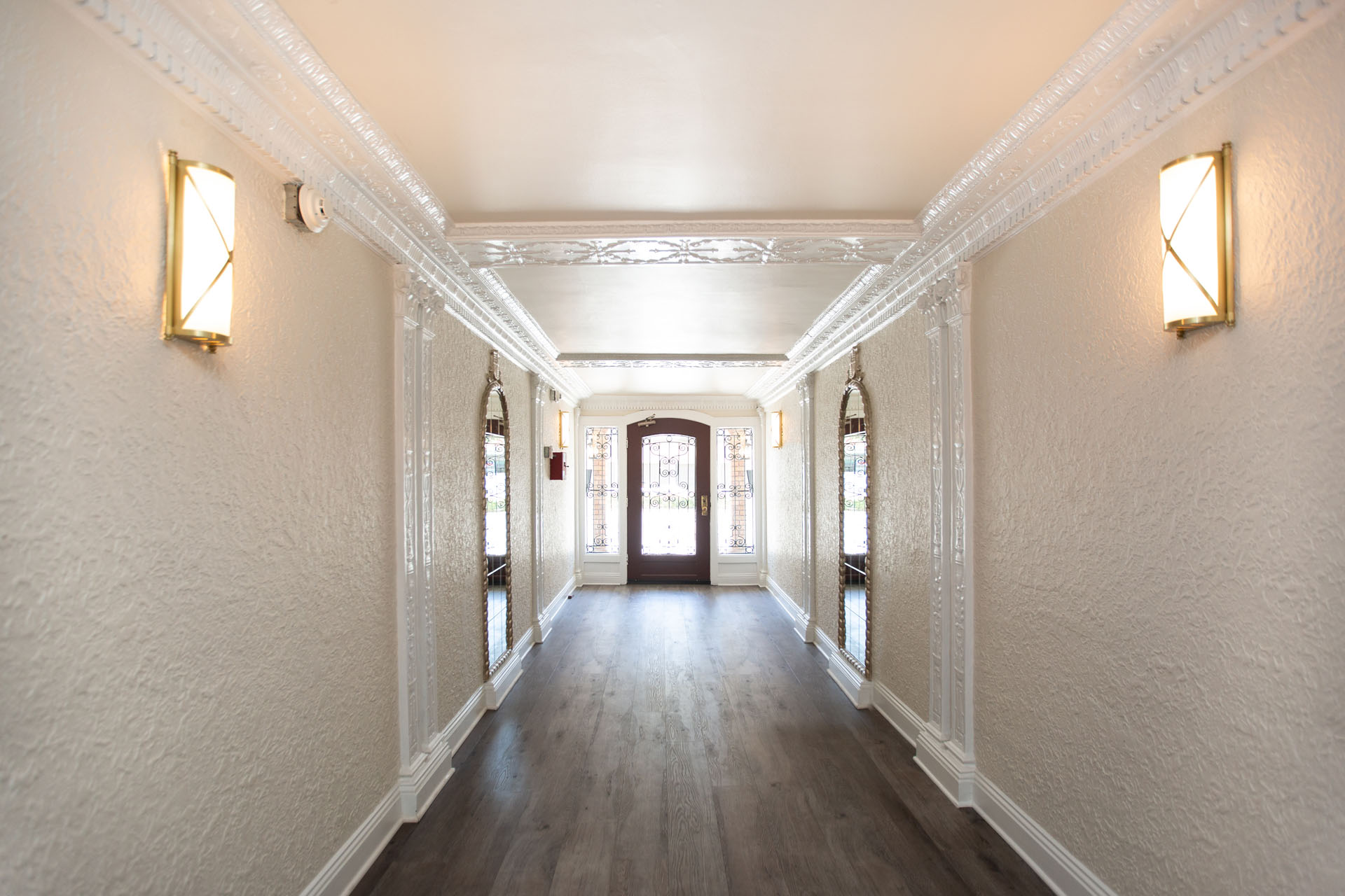 A long hallway with white walls and wood floors.