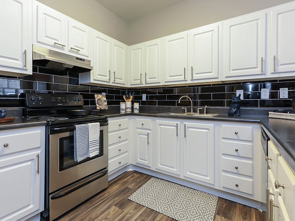 a kitchen with white cabinets and stainless steel appliances