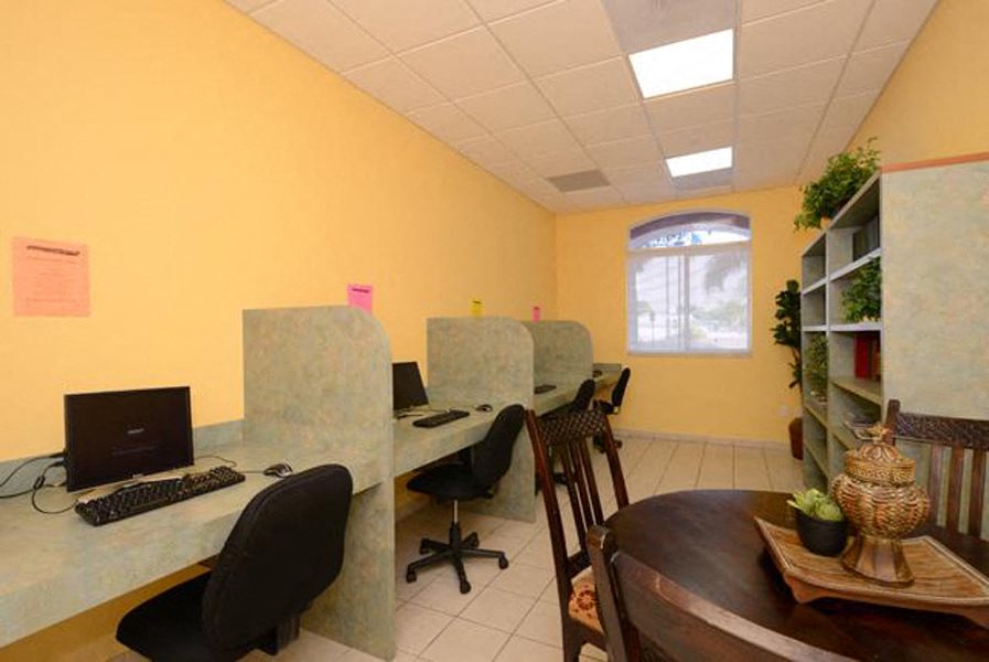 a office with a table and chairs and a computer