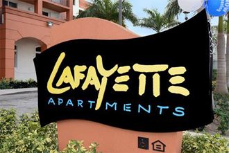 a black and yellow sign with the name of a apartment building