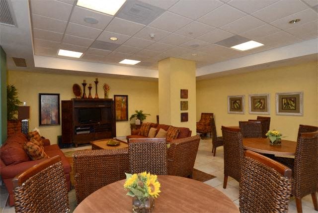 a living room with tables and chairs and a television