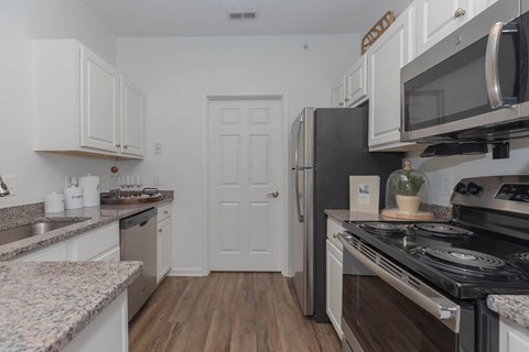 a kitchen with stainless steel appliances and white cabinets