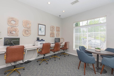 a conference room with desks and chairs and a window