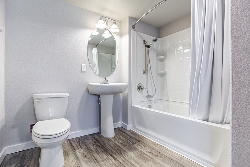American Canyon Apartments- The Village at Vintage Ranch- Shower and Bathtub with White Vanity Sink and Wood-Style Floors