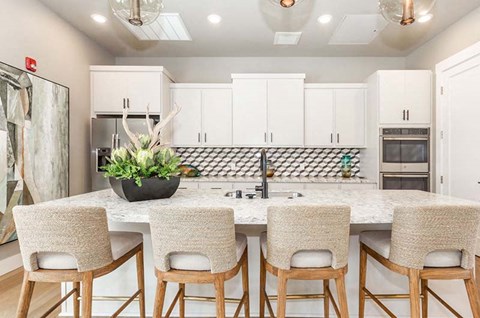 a kitchen with a large island with four chairs