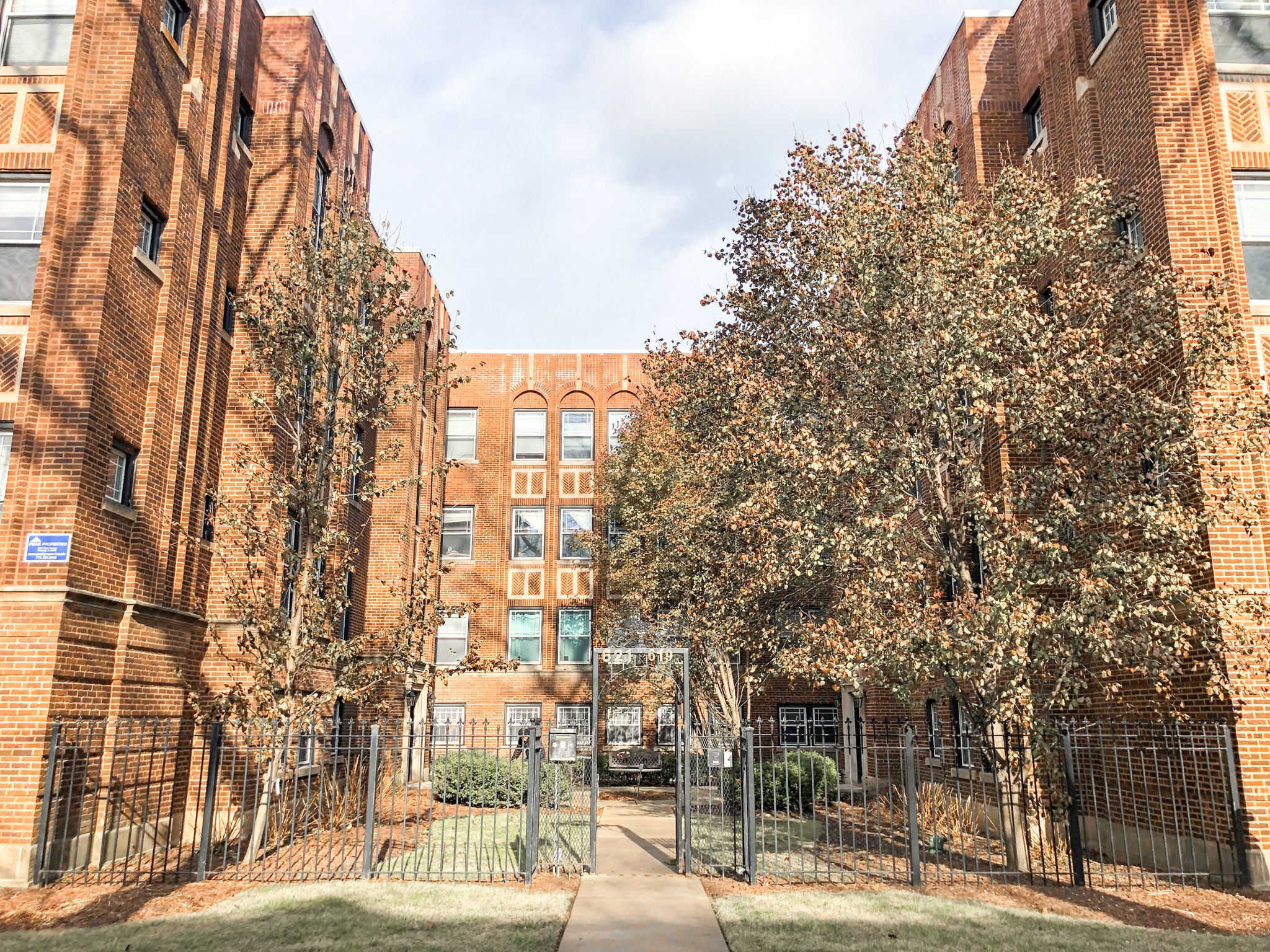 a wrought iron fence in front of a brick building