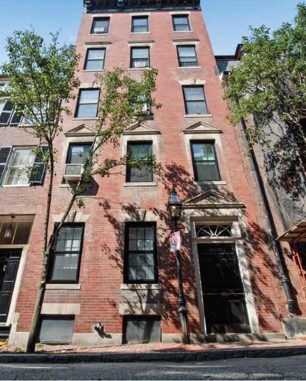 a tall brick building with trees in front of it