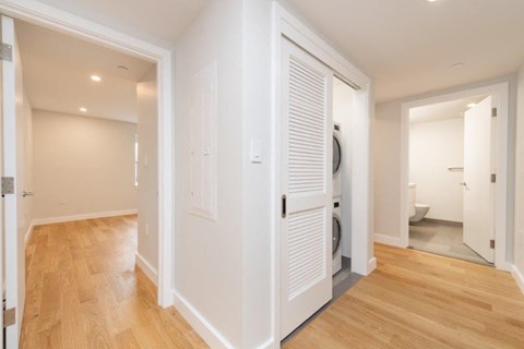 a living room with a door to a washer and dryer